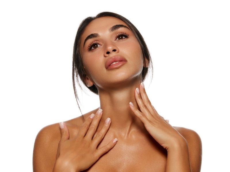 A woman with a radiant tan poses in front of the camera