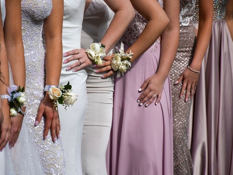 Girls with tanned skin pose for prom.