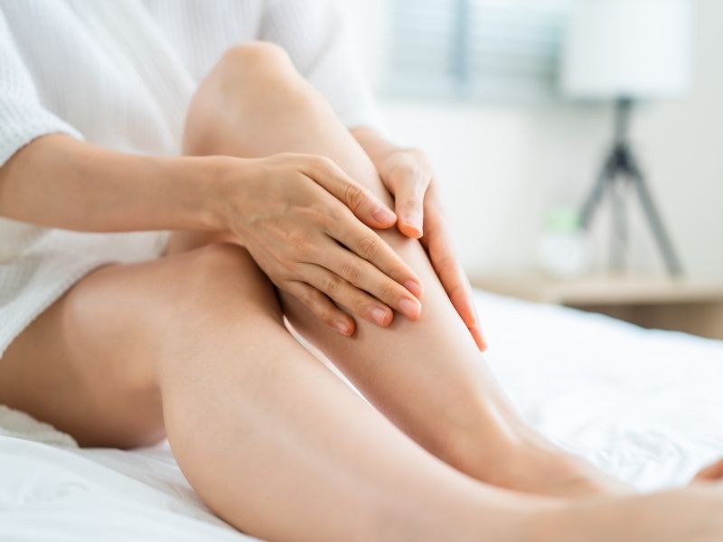 A woman applies lotion in preparation of a spray tan.